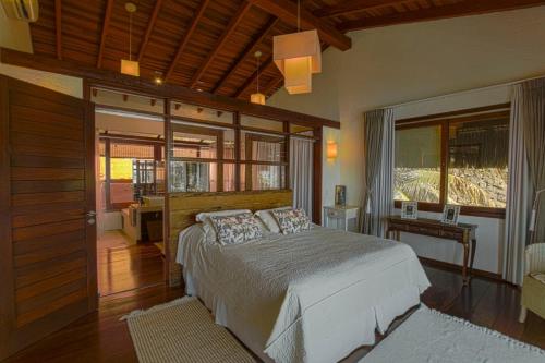 a bedroom with a large bed and a window at Villa Bermahe in Ilhabela