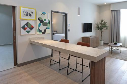 a living room with a table and a bedroom at Holiday Inn Navojoa by IHG in Navojoa