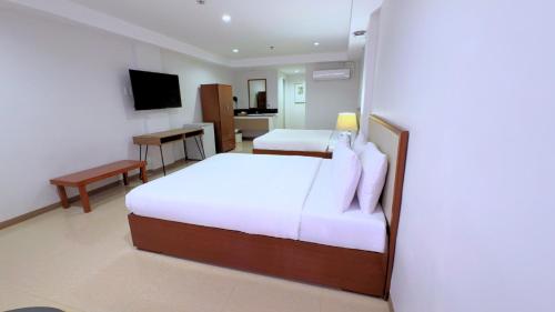 a hotel room with a bed and a desk at Whiterock Beach Hotel and Waterpark in Subic