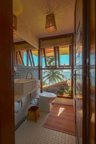 a bathroom with a sink and a toilet and a window at Villa Bermahe in Ilhabela