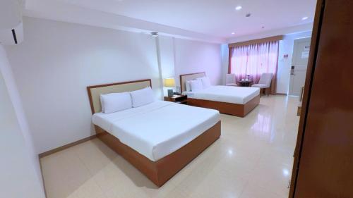 a hotel room with two beds and a couch at Whiterock Beach Hotel and Waterpark in Subic