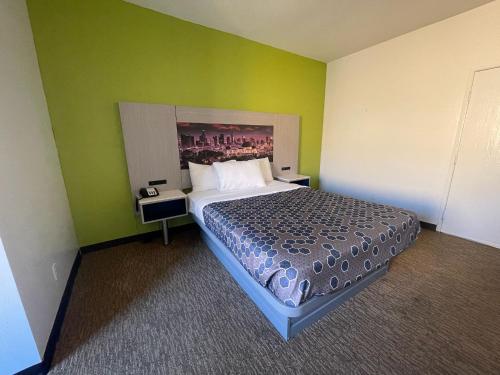 a bedroom with a bed and a green wall at Hotel Pacific Garden in Gardena