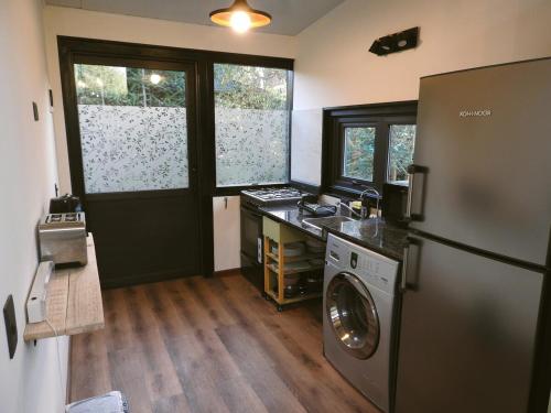 eine Küche mit einem Kühlschrank und einer Waschmaschine in der Unterkunft Cabaña Kunl Villa La Angostura moderna y accesible in Villa La Angostura