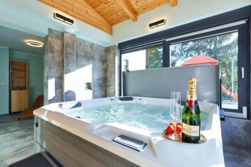 a bathroom with a tub with a bottle of champagne at Family friendly house with a swimming pool Karlovac - 22371 in Karlovac