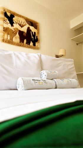 a white bed with two pillows on top of it at Hotel Riviera Inka Paracas in Paracas