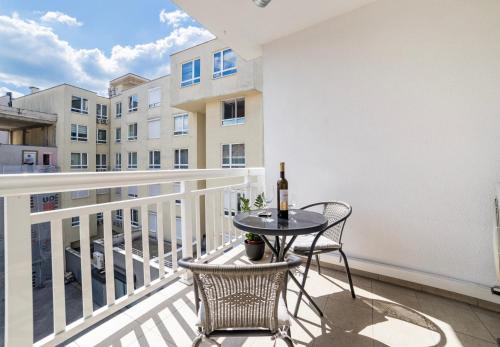 a balcony with a table with a bottle of wine at Skenderija Skyline Luxury- 2BR Apartment with Garage and Balcony in Sarajevo