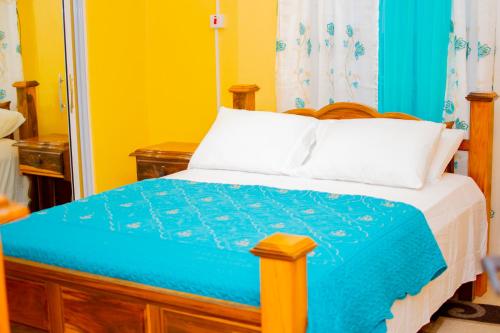 a bedroom with a bed with a blue comforter at Comfortable 1 bedroom with bath in Santa Cruz
