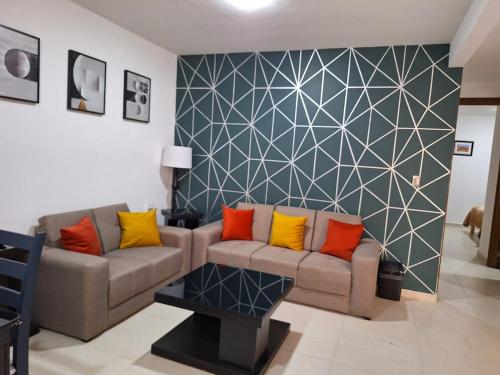 a living room with a couch and a geometric wall at Casa Coruña in Durango in Durango