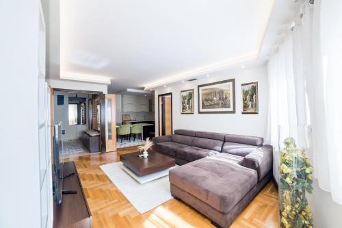 a living room with a couch and a table at Skenderija Skyline Luxury- 2BR Apartment with Garage and Balcony in Sarajevo