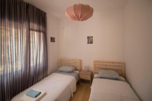 two twin beds in a room with a window at Family friendly house with a swimming pool Rukavac, Vis - 24700 in Vis