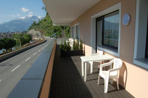 a white table and chairs on a balcony with a road at Appartement Alpensee in Zell am See