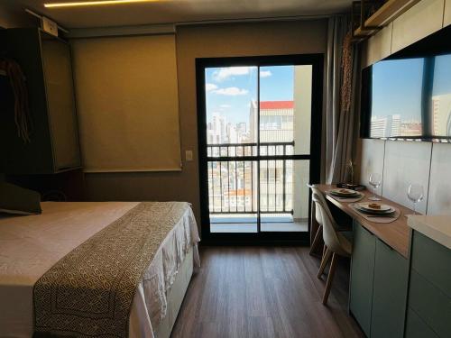 una camera da letto con un letto, una scrivania e una finestra di IBZ2108 - Studio Luxuoso no Centro de Curitiba a Curitiba