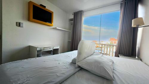 a bedroom with a bed with a window and a desk at Hotel Riviera Inka Paracas in Paracas