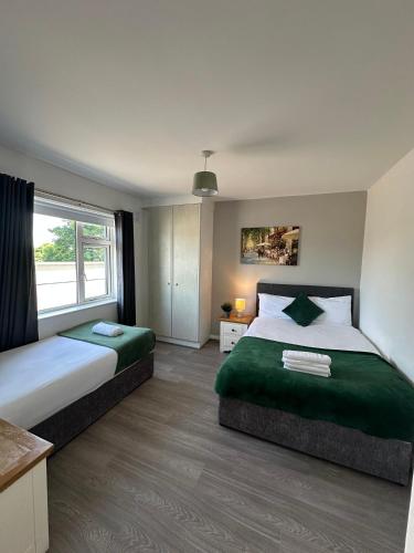 a bedroom with two beds and a window at Newcastle Townhouse in Galway