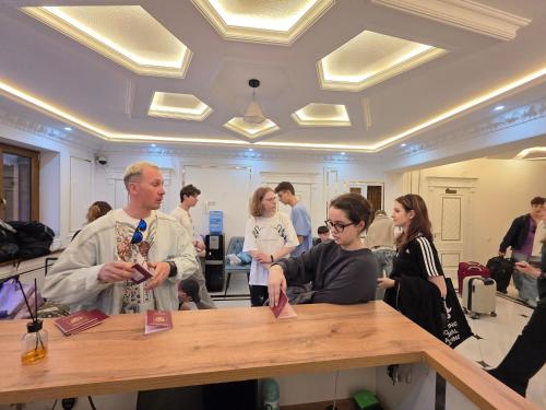 a group of people standing around a table in a room at Samarkand Imron Hotel in Samarkand
