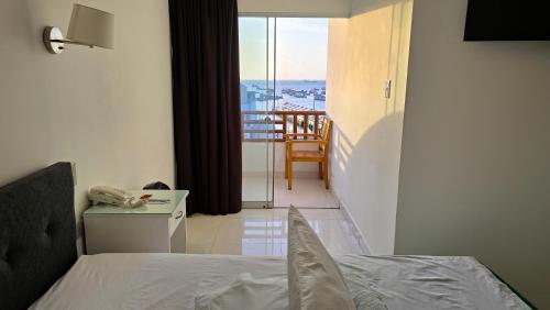 a bedroom with a bed and a view of a balcony at Hotel Riviera Inka Paracas in Paracas