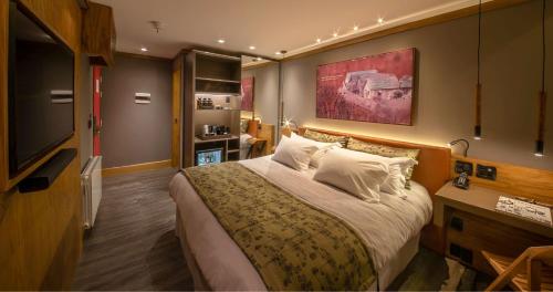 a hotel room with a bed and a flat screen tv at Wood Hotel in Gramado