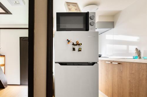 a refrigerator with a tv on top of it in a kitchen at ELIM Private Vacation Home near Umeda Japanese-style Entire 3BR House with Tea Room in Osaka