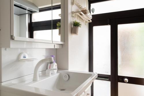 a white sink in a bathroom with a window at ELIM Private Vacation Home near Umeda Japanese-style Entire 3BR House with Tea Room in Osaka