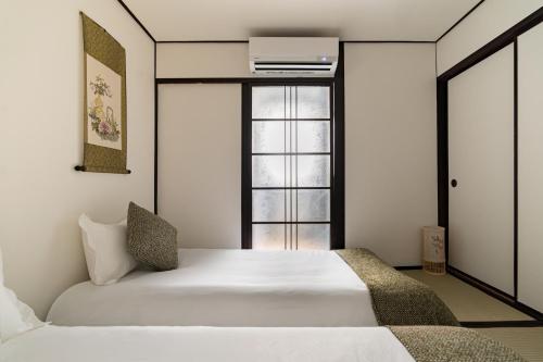 a bedroom with a white bed and a window at ELIM Private Vacation Home near Umeda Japanese-style Entire 3BR House with Tea Room in Osaka