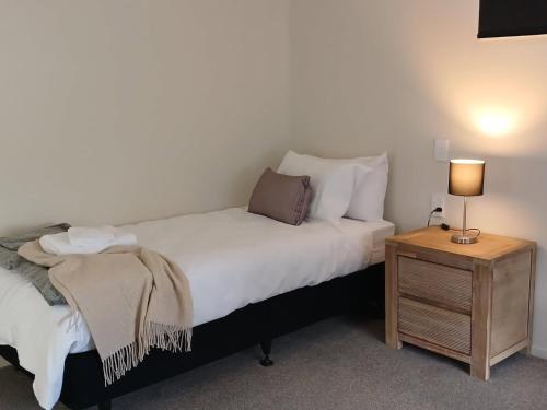 a bedroom with a bed and a night stand with a lamp at Suncrest Villas in Cromwell