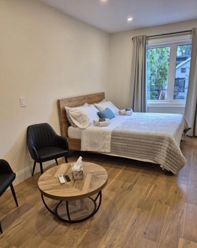 a bedroom with a bed and a table and a chair at Gabby's Place Downtown Core in Toronto