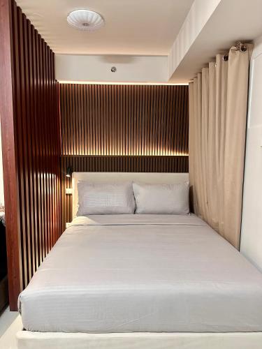 a bedroom with a bed with a wooden headboard at Tey Spot in Iloilo City