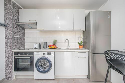 a kitchen with a washing machine and a dishwasher at Appartement Grenade, Idéal Famille, Jardin Privatif, Piscine in Abondance