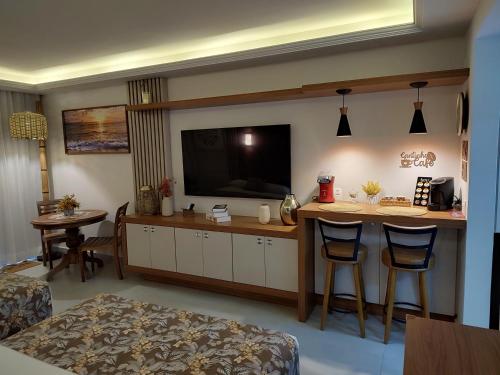 a living room with a bar with a flat screen tv at Búzios Beach Resort Apartamento Luxo Home Premium 2 in Búzios