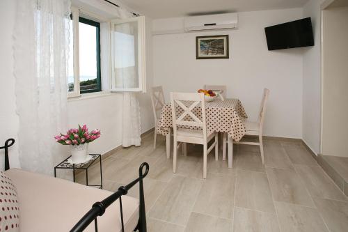 a kitchen and dining room with a table and chairs at Holiday Home Miklica in Klis