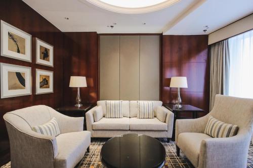 a living room with a couch and chairs and a table at Shanghai Marriott Marquis City Centre in Shanghai