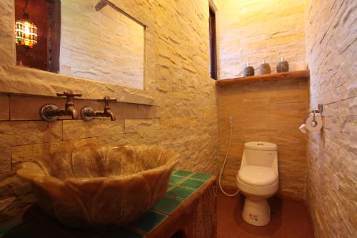 a bathroom with a wooden tub and a toilet at Jialeshuel Surf house B&B in Manzhou