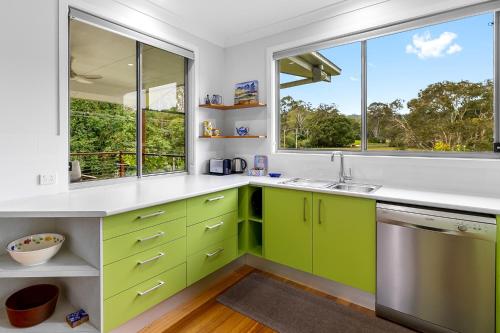 a kitchen with green cabinets and a window at Quiet Ninderry Cottage with Peaceful Rural Outlook in Ninderry
