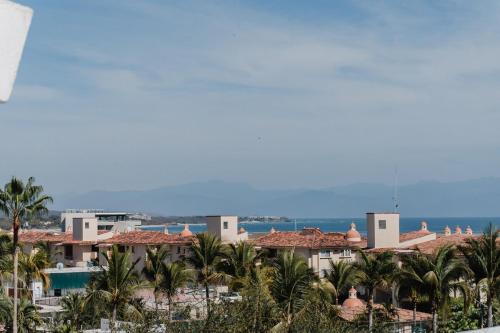 a view of a resort with palm trees and the ocean at Apartment Ola Mita in Punta Mita