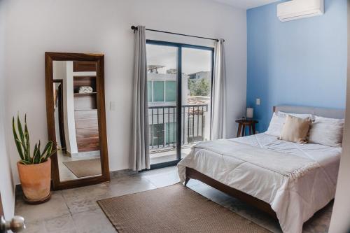 a bedroom with a bed and a window with a balcony at Apartment Ola Mita in Punta Mita