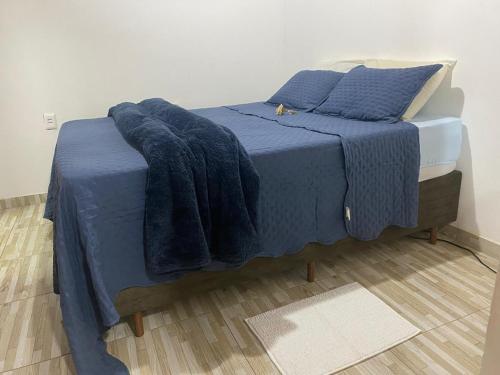 a blue bed with blue sheets and pillows on it at Suite Aconchego in Mucugê