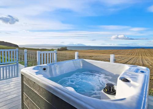 bañera en una terraza con vistas a un campo en Heads Of Ayr Holiday Park, en Ayr