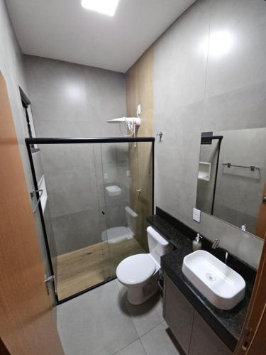 a bathroom with a toilet and a sink and a shower at Flat Santa Teresa in Campo Verde