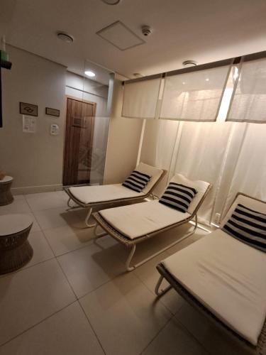 a room with three mattresses and chairs in it at Helbor Stay Santos Pompéia Gonzaga - Varanda vista mar in Santos