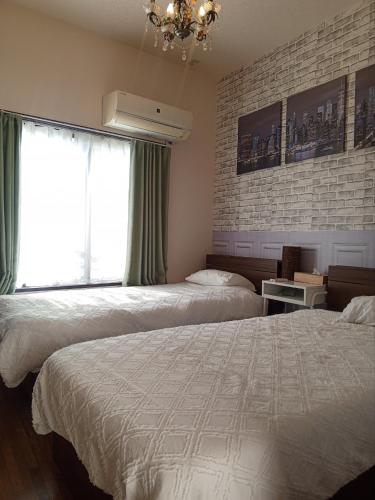 une chambre avec deux lits et une fenêtre avec un lustre dans l'établissement 301singleroom 1, à Tokyo