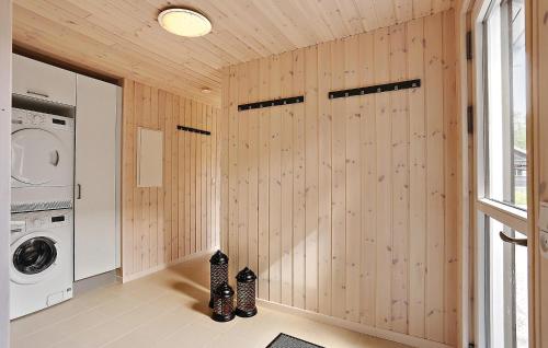a laundry room with wooden walls and a washer and dryer at Holiday Home Frederiksværk With Fireplace 10 in Frederiksværk