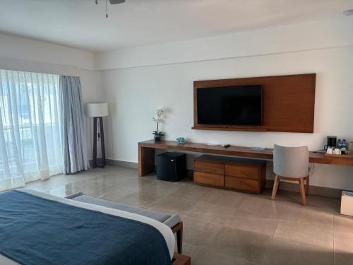 a hotel room with a bed and a flat screen tv at Lifestyle Cabarate in Cabarete