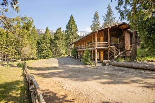 a log cabin with a road in front of it at Camp Nelson Lodge Room 10 in Ponderosa