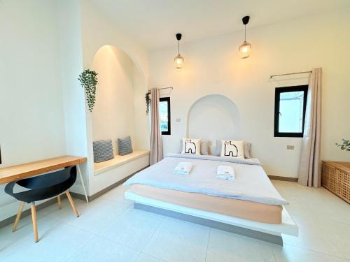 a bedroom with a large bed and a desk at Medina Private Pool Villa-บางแสน in Ban Puk (1)