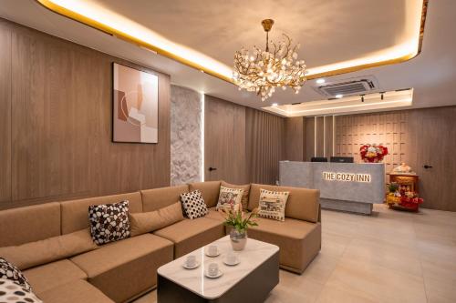 a living room with a couch and a chandelier at The Cozy Inn Hotel Ho Chi Minh in Ho Chi Minh City