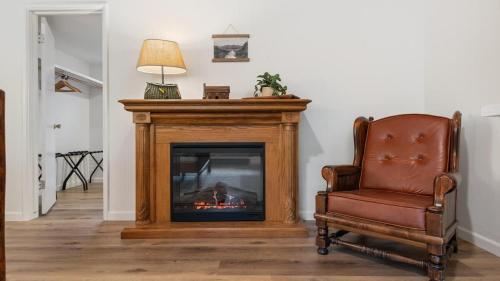 a living room with a fireplace and a chair at Camp Nelson Lodge Room 6 in Ponderosa