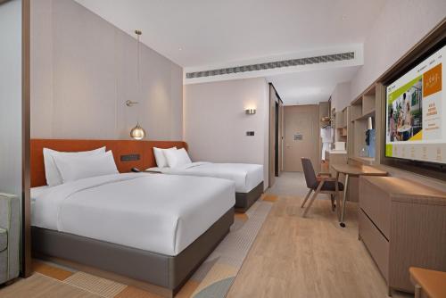 Postel nebo postele na pokoji v ubytování Home2 Suite by Hilton Nantong Vientiane City