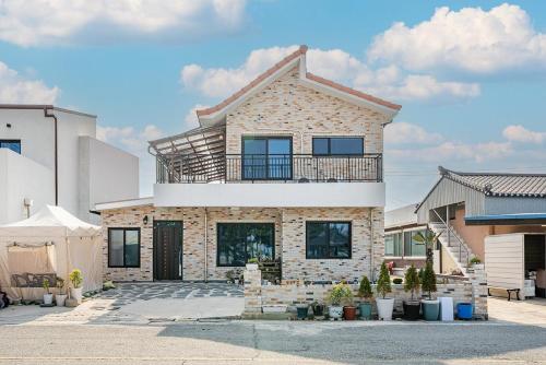 a house with a balcony on top of it at Uljin Jeongdam-eun Ocean View Pension in Uljin