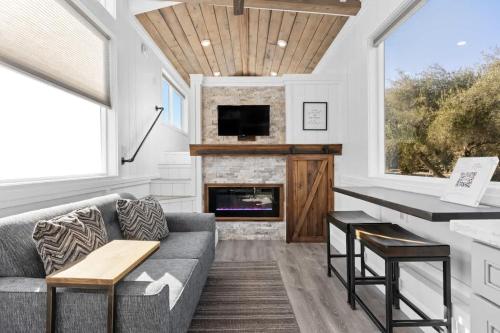 a living room with a couch and a fireplace at Tiny Home | Lewis Ranch 1 in Lindsay