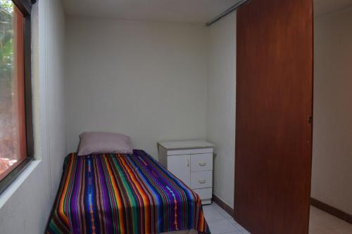 a small bedroom with a bed and a dresser at Casa Gaspar on Lake Atitlán in San Antonio Palopó